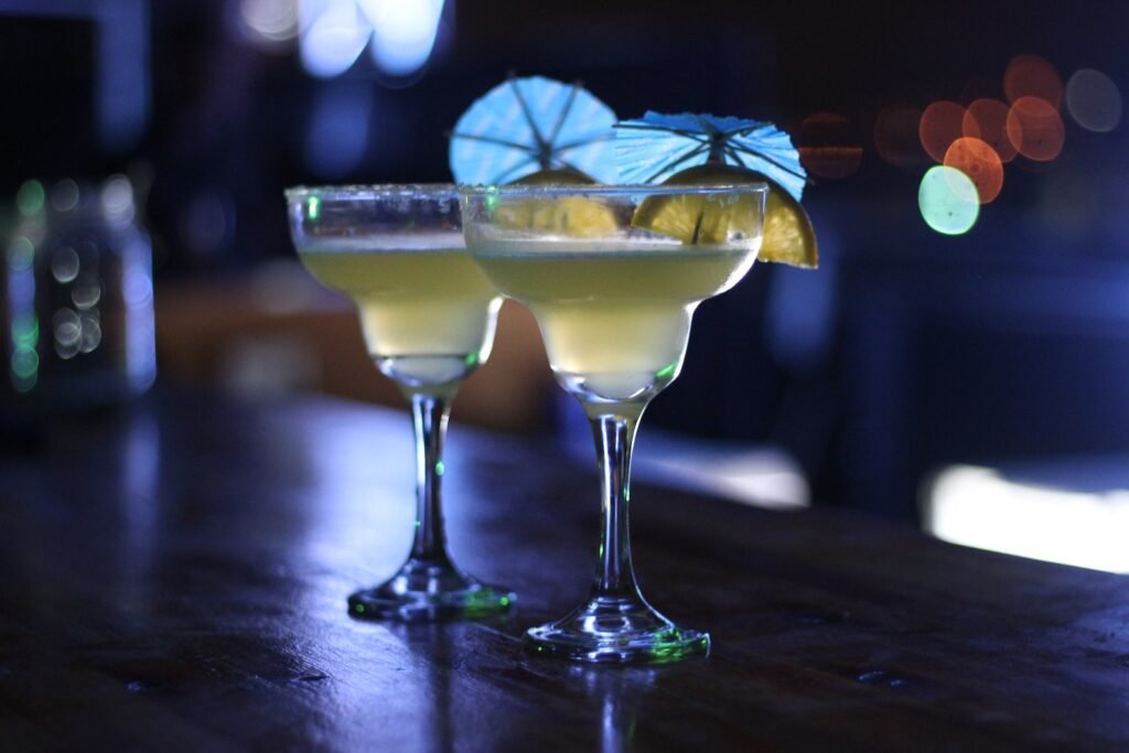 Two Margarita Glasses on Brown Wooden Surface